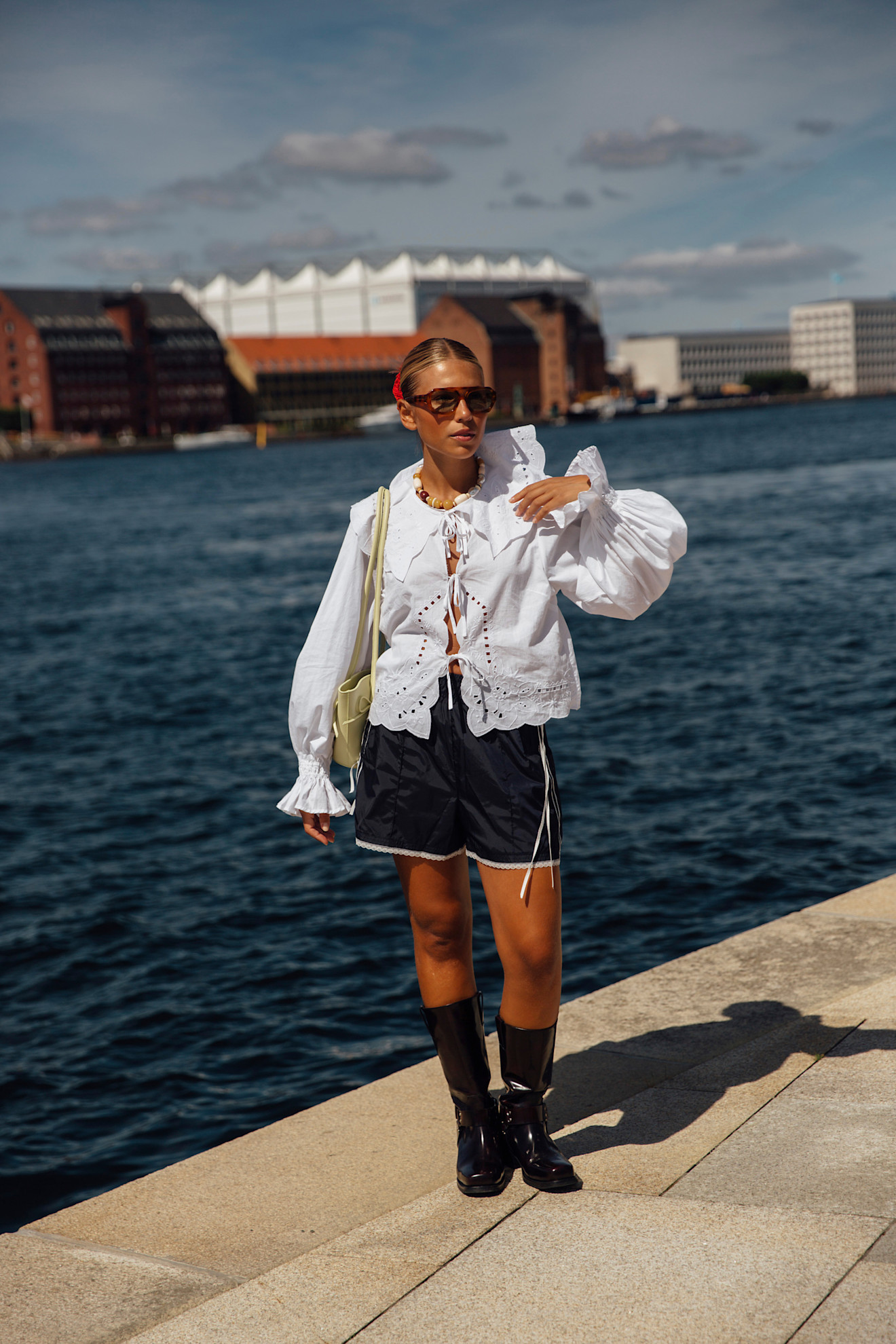 woman wearing track shorts and a lacy blouse in Copenhagen.