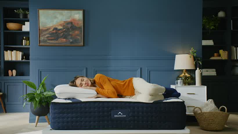 Woman resting on her side on a DreamCloud Mattress