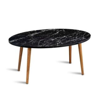 A circular black marble coffee table with four wooden legs