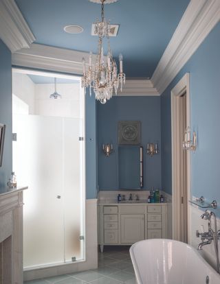 blue bathroom with ornate chandelier by Farrow & Ball
