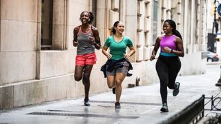 Three women running on pavement and chatting