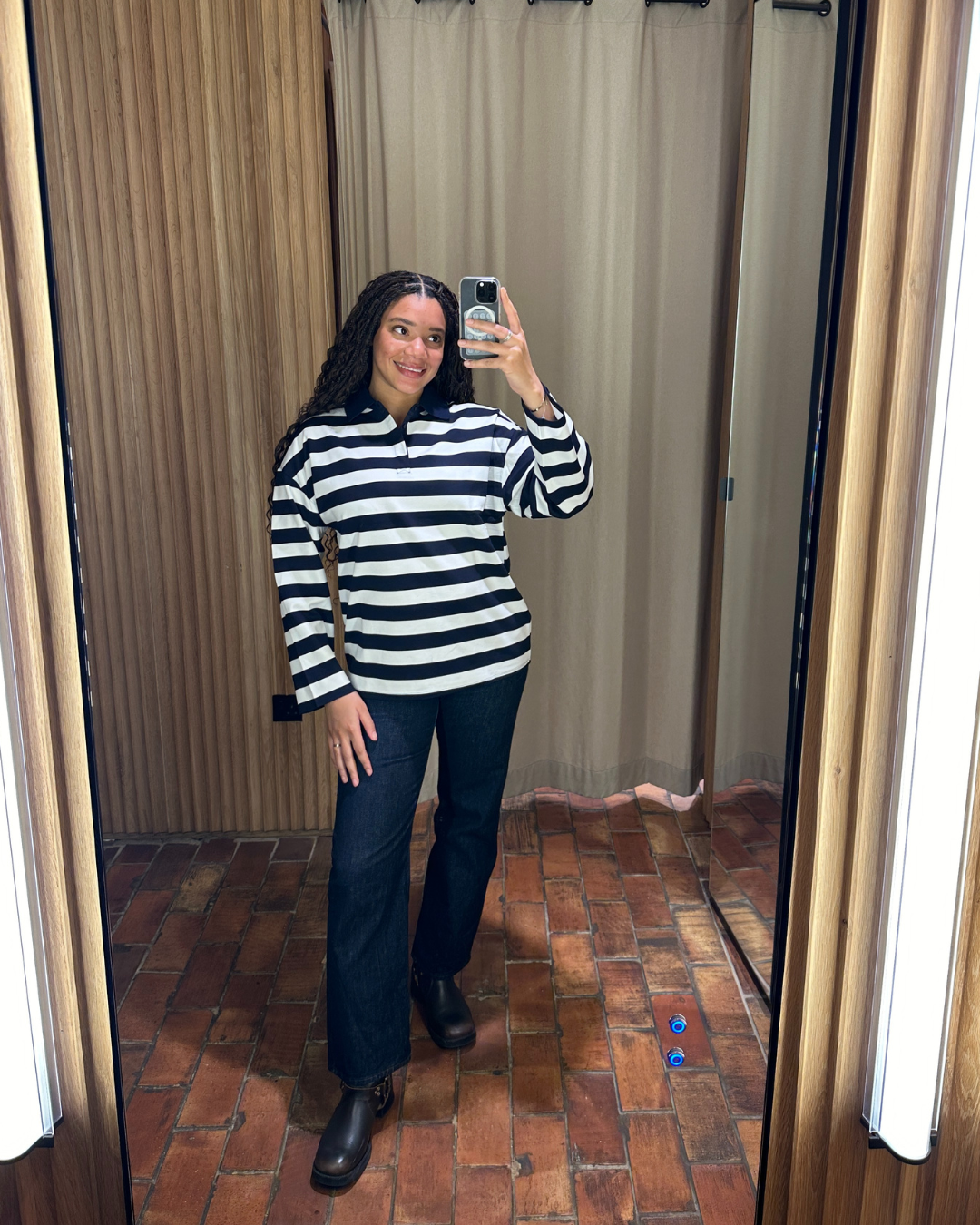 Imani-Nia Francis-Tsolakis in a blue and white Mango polo top dark blue jeans and biker boots.