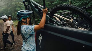 Riders unload mountain bikes from a pickup