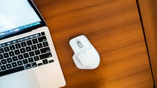 A white Logitech MX Master 3S for Mac mouse on a brown wooden desk