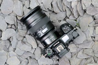Nikon Z 24-70mm f/2.8 S lens attached to camera on a stony beach