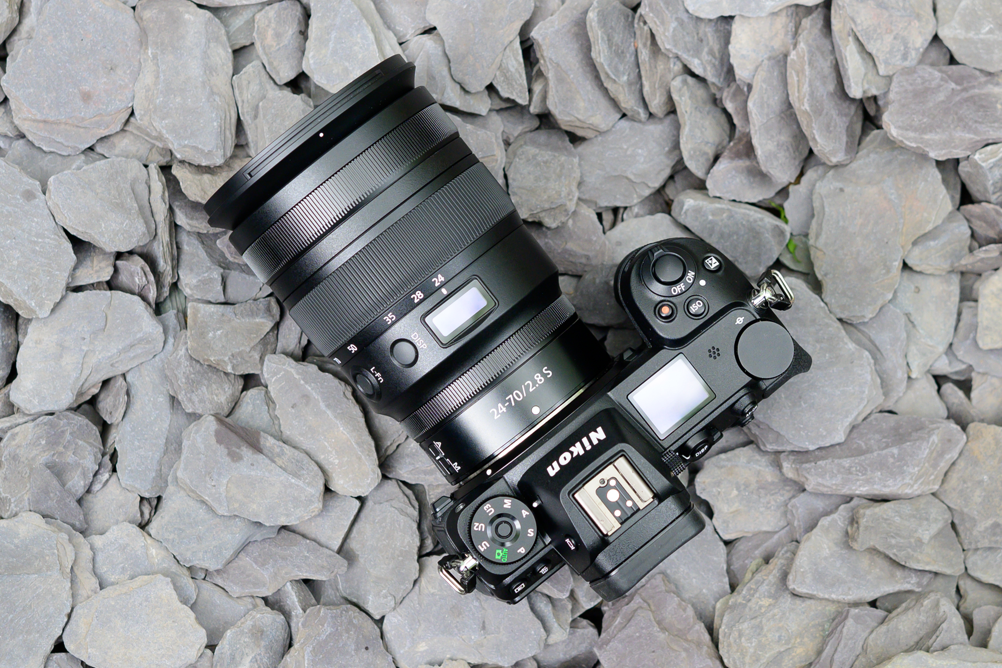 Lente Nikon Z 24-70mm f/2.8 S conectada a la cámara en una playa pedregosa