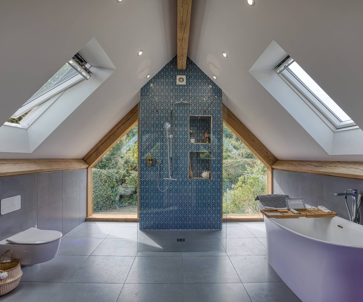 bathroom in pitched roof oak frame extension with feature shower wall, oak exposed beams, large glazed panels and skylights
