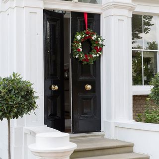white wall with christmas wreath and front door