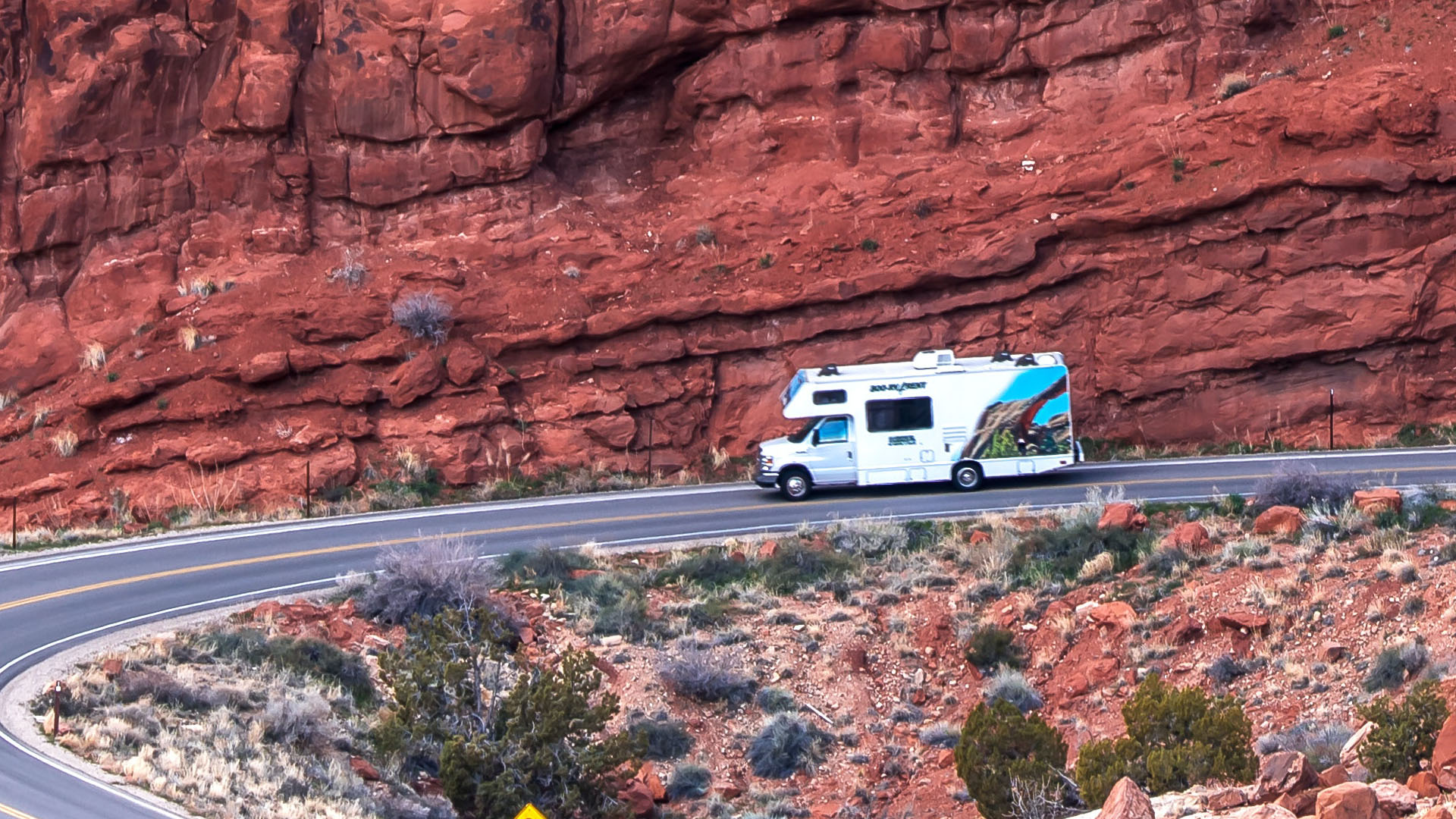 RV parked on a road in a dramatic landscape