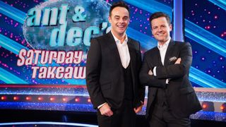 Ant & Dec in front of the Saturday Night Takeaway board