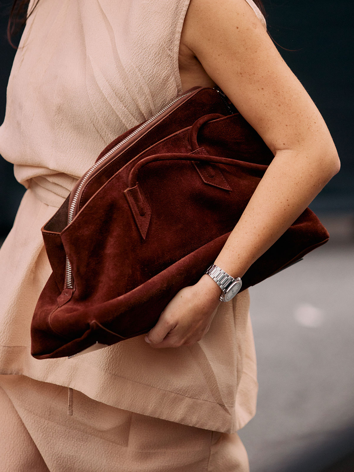 Woman carrying a suede The Attico handbag.