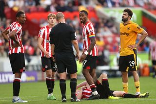 Referee Robert Madley speaks with Diego Costa of Wolverhampton Wanderers, before Diego Costa receives a red card following a VAR Review, during the Premier League match between Brentford FC and Wolverhampton Wanderers at Brentford Community Stadium on October 29, 2022 in Brentford, England.