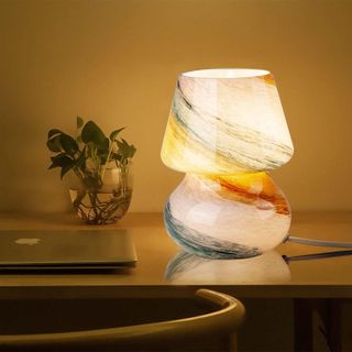 mushroom glass lamp on a desk with a swirling colorful design