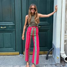 Influencer Sara Ramén wears La Veste red striped pants with a green tank in Paris. 