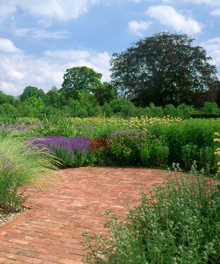handmade brick pavers used as a path and patio, surrounded by prairie style planting