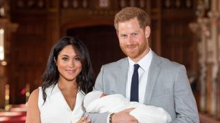 Prince Harry, Duke of Sussex and Meghan, Duchess of Sussex, pose with their newborn son Archie Harrison Mountbatten-Windsor during a photocall in St George's Hall at Windsor Castle on May 8, 2019 in Windsor, England