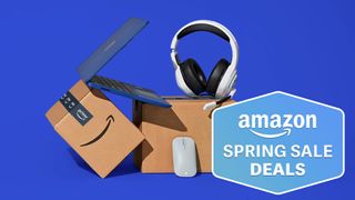 A laptop and headphones lying atop Amazon Prime boxes