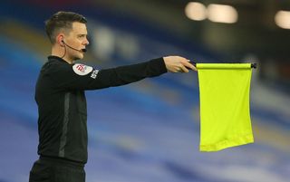Assistant referee James Mainwaring raises his flag