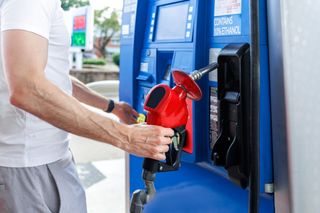 Close-up of man preparing to refuel his car at gas station.