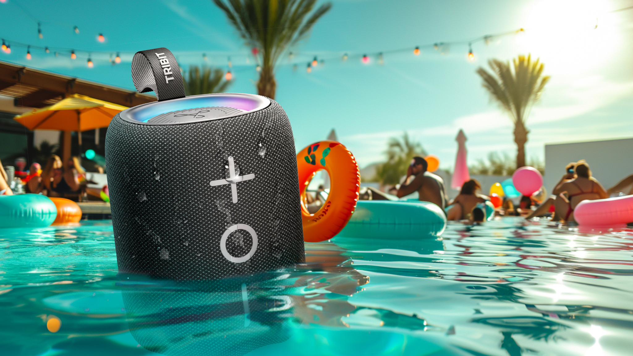 A Tribit StormBox Mini+ bluetooth speaker floating in a busy swimming pool on what appears to be a hot day