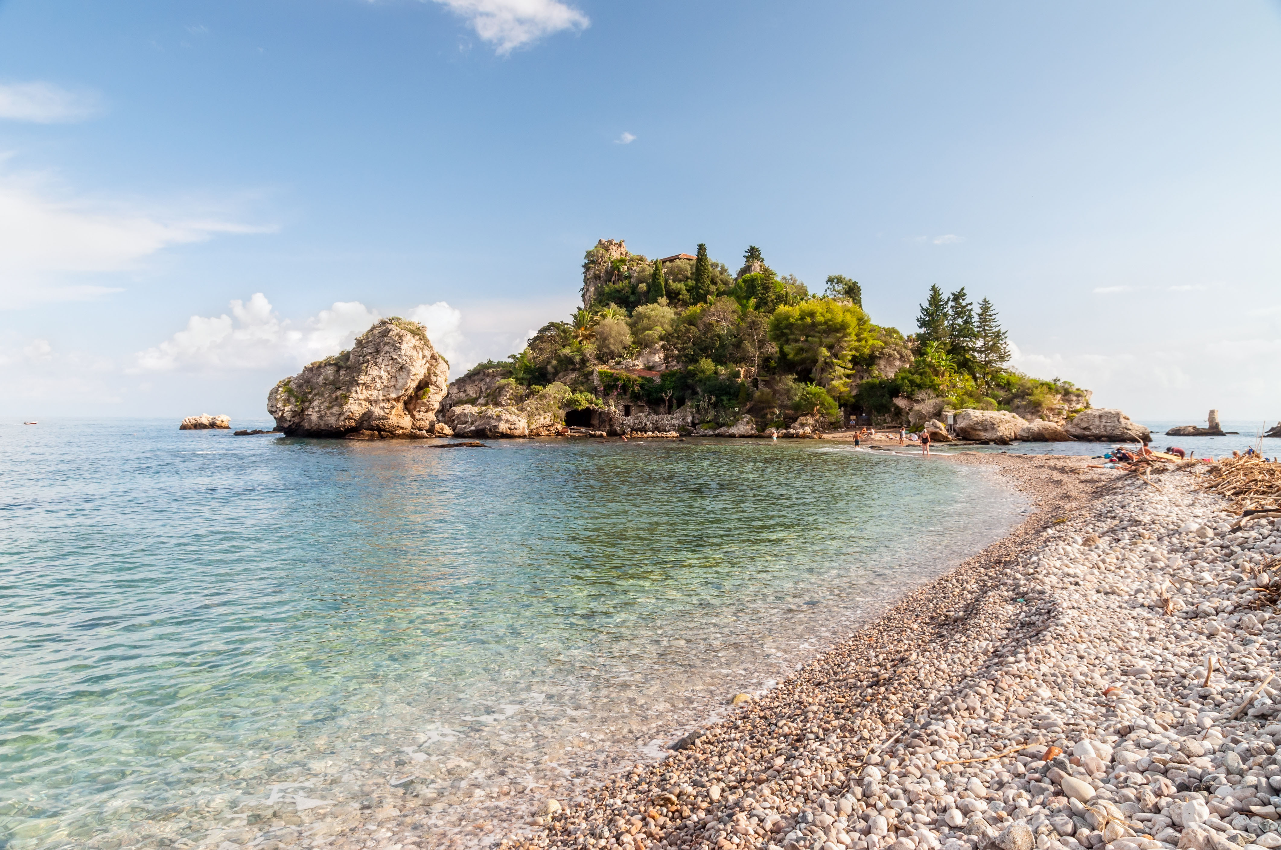 Pebble causeway leading to a small, tree-covered island