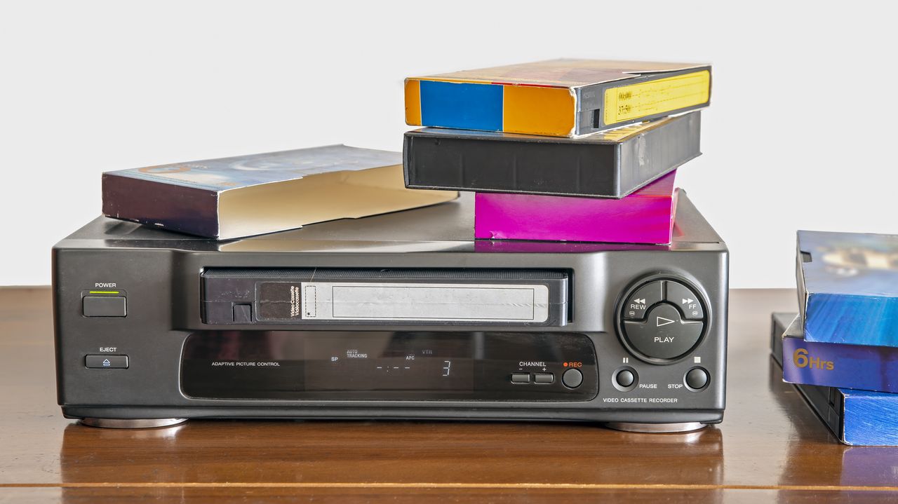 Stack of VHS tapes on top of a VHS player.