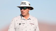 Joel Dahmen during a PGA Tour event wearing a white bucket hat and sunglasses