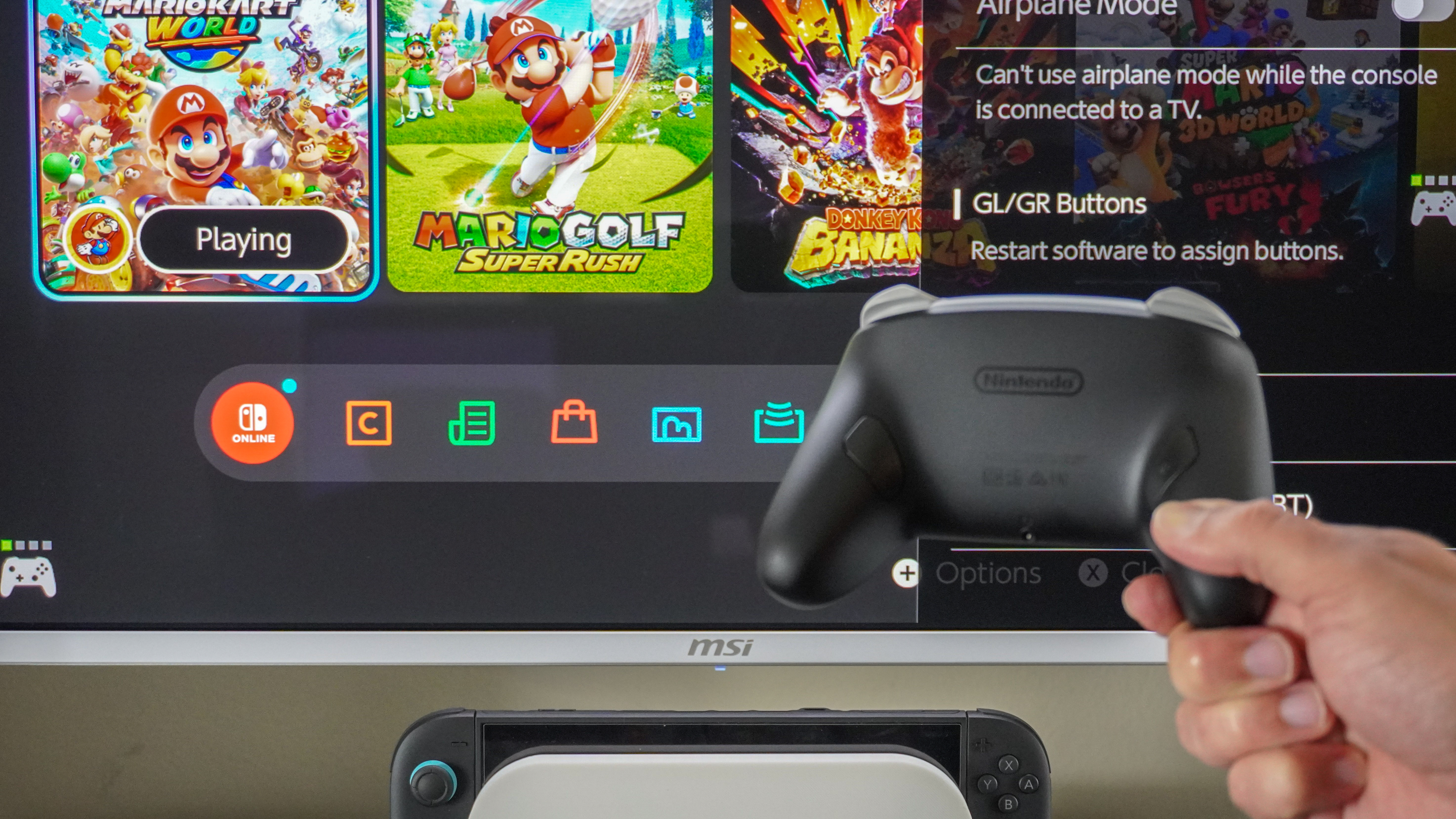 A Nintendo Switch 2 Pro Controller in hand in front of the Switch 2's Quick Settings menu