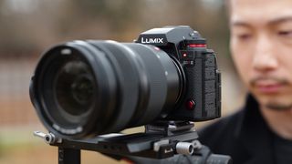 A close-up of the LUMIX S1RII, mounted on a tripod, showcasing its detailed design