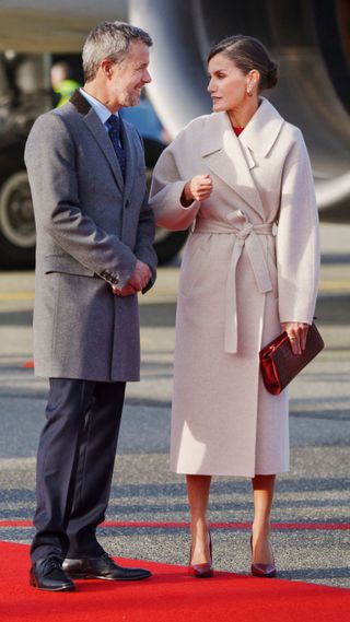 Crown Prince Frederik of Denmark and Queen Letizia of Spain react during a welcoming ceremony upon arrival at the airport in Copenhagen