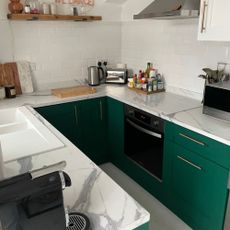 Small kitchen with green cabinets and a marble worktop