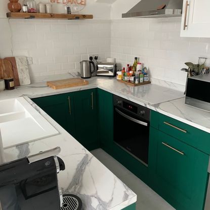 Small kitchen with green cabinets and a marble worktop