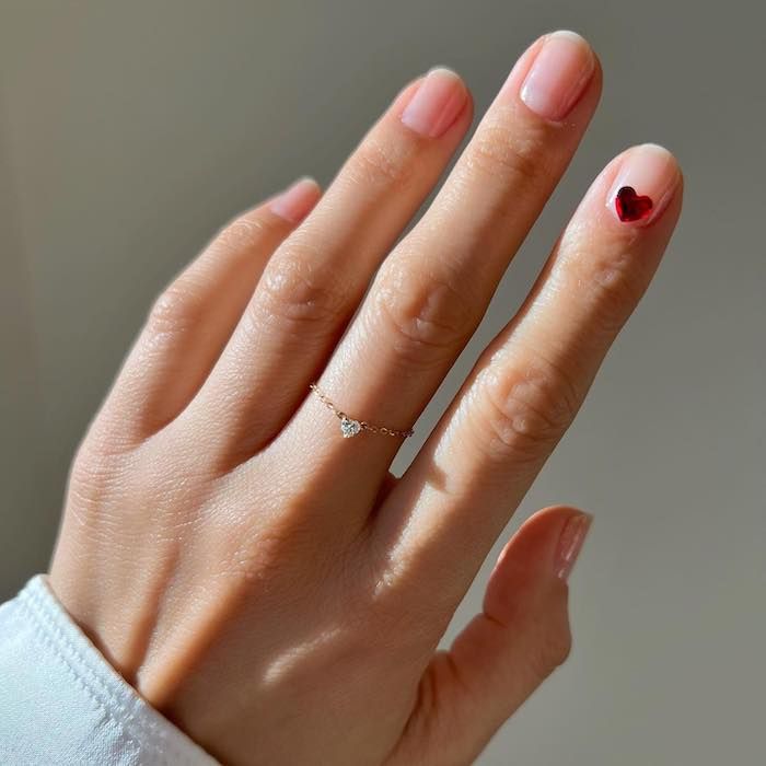 Red heart charm on nude nails