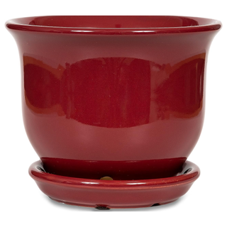 A deep red planter with an attached saucer