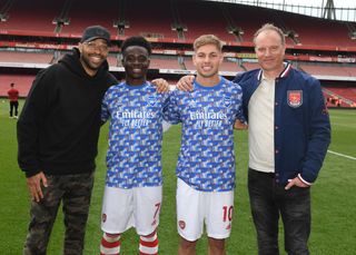 Ex Arsenal players (L) Thierry Henry and (R) Dennis Bergkamp with current players (2ndL) Bukayo Saka and (2ndR) Emile Smith Rowe after the Premier League match between Arsenal and Manchester United at Emirates Stadium on April 23, 2022 in London, England.