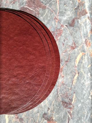 leather placemats on a marble backdrop