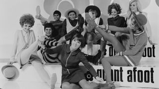 English fashion designer Mary Quant with models at the launch of her 'Quant Afoot' range of boots in fashion colours, London, 15th August 1967. The boots are covered in clear plastic to keep the colours fresh and the surface shiny.