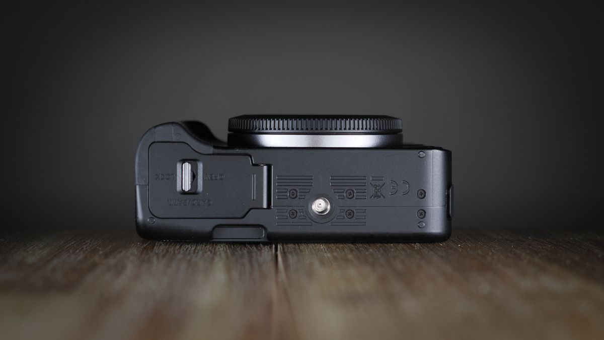 Canon EOS R50 V on a wooden surface, against a dark background