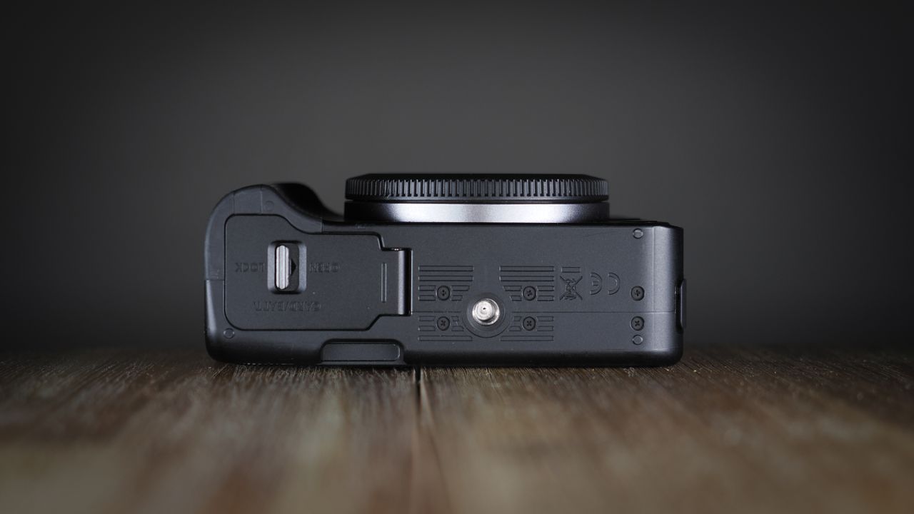 Canon EOS R50 V on a wooden surface, against a dark background