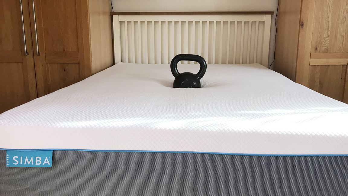 Image shows a black 25KG weight place in the middle of a Simba Hybrid Pro Mattress