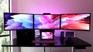 three WQHD monitors on a desk displaying a desktop