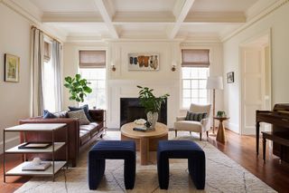 Living room with dark wood flooring, Berber rug, brown leather sofa and cobalt blue armchairs