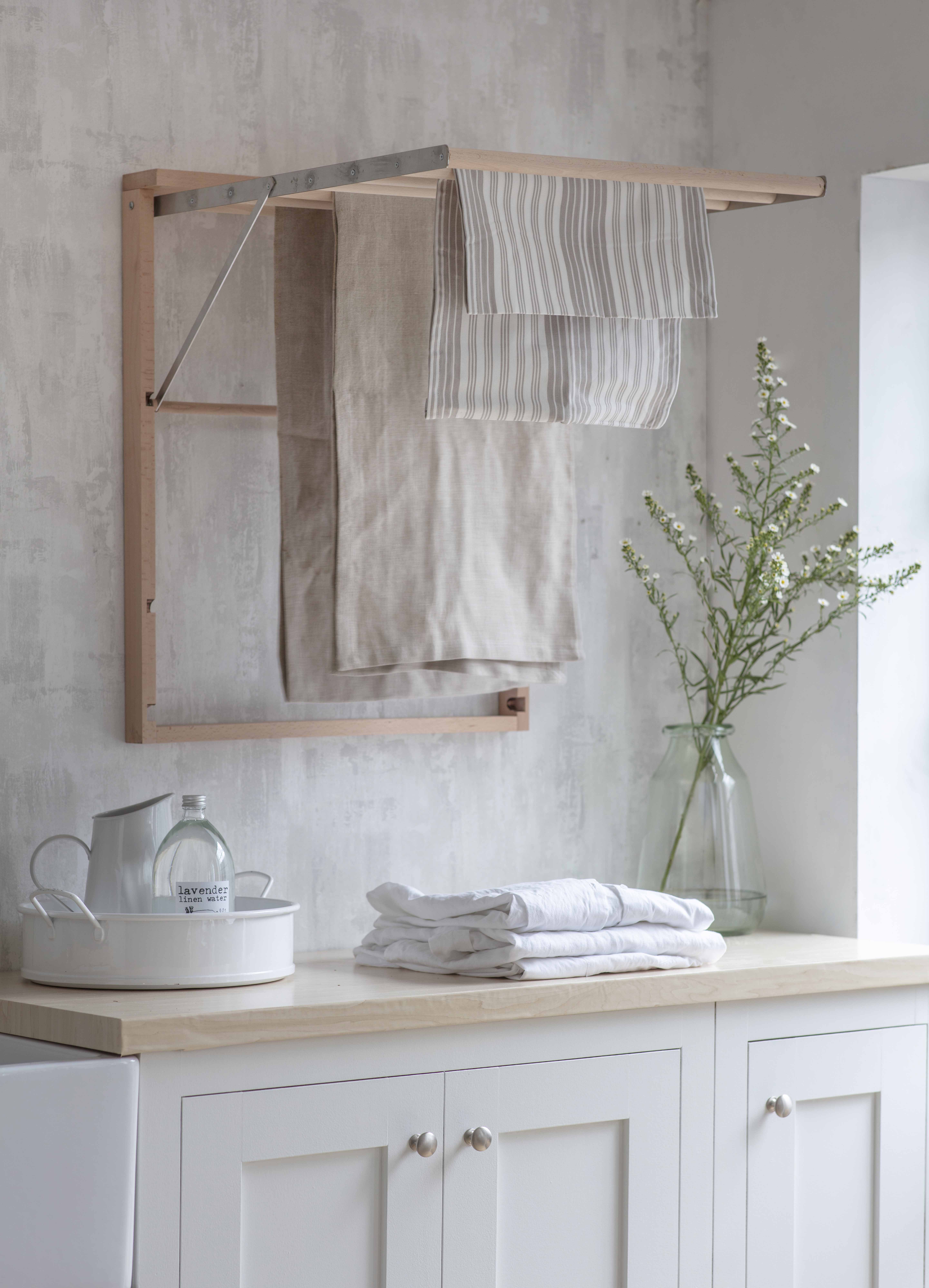 A simple utility room with a muted color scheme and fold-out airers
