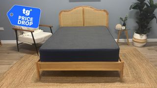 The Brooklyn Bedding CopperFlex Essential Mattress on a wooden bed frame in a bedroom setting. A deals badge is seen in the top left foreground. 