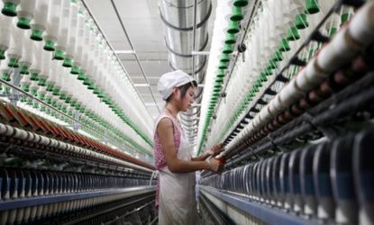 A Chinese worker handles the production of yarn to be be exported: China has relied heavily on cheap exports to build its economy, which is expected to slow.