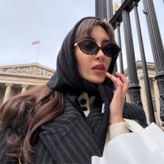An image of Alyssa Brascia wearing a head scarf and sunglasses in London.