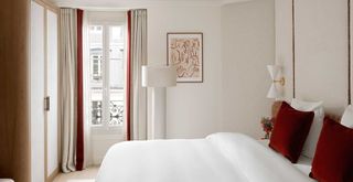 neutral Parisian style decor bedroom with burnt orange velvet accessories