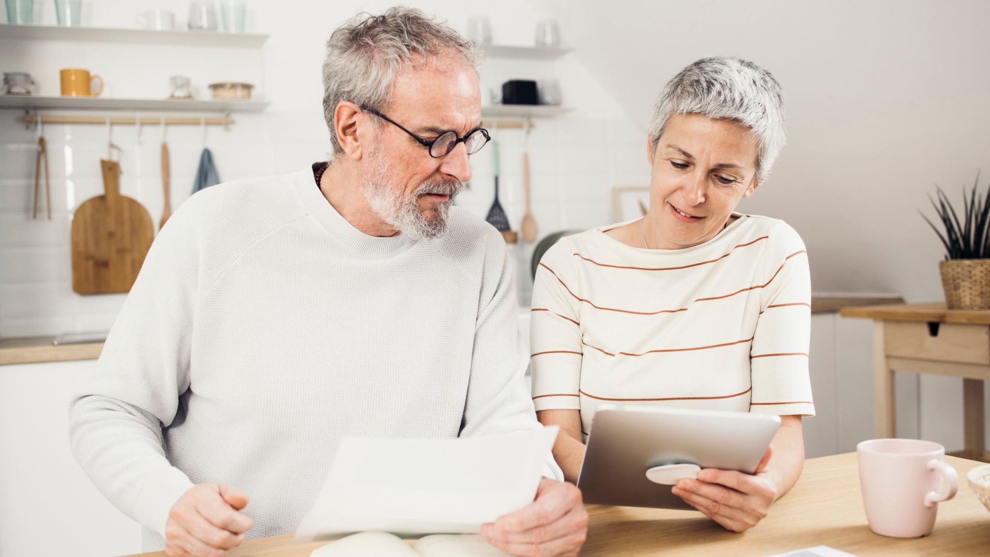 Portrait of a senior couple managing their finances together at home.