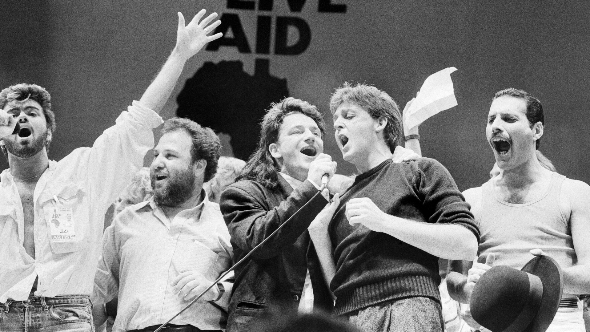 George Michael, promoter Harvey Goldsmith, Bono, Paul McCartney and Freddie Mercury performing on stage during the finale of Live Aid at Wembley