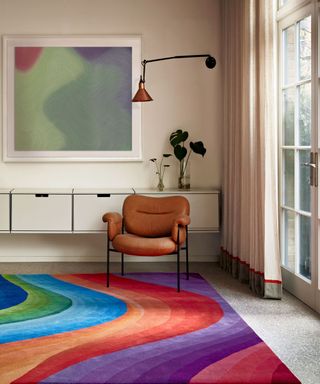 A colorful, wavy rug in a neutral room with a brown leather chair